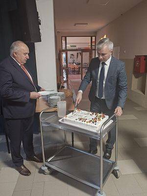 Radny Marek Baranowski razem z Dyrektorem Krzysztofem Pruszakiem kroją tort przygotowany dla przybyłych gości.