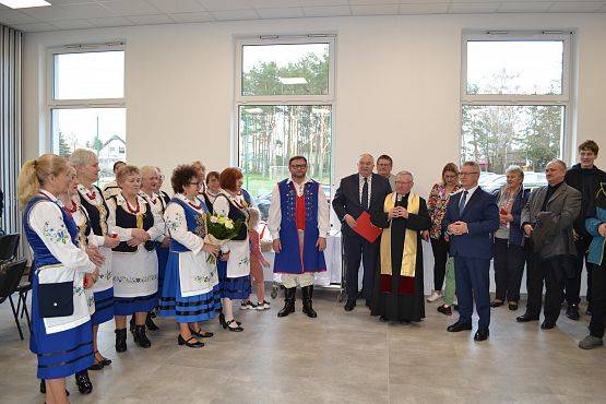 Wspólne zdjęcie członków KGW, dyrektora, księdza proboszcza oraz gości w nowej sali.