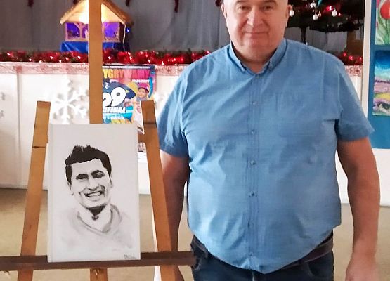 Dyrektor GOK na sali obok portretu Lewandowskiego