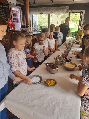 Grupa dzieci w pizerii podczas robienia pizzy
