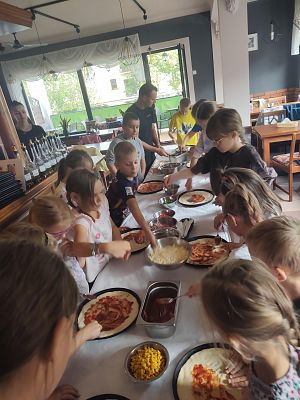 Grupa dzieci w pizerii podczas robienia pizzy