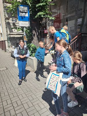 Dzieci stoją na przystanku autobusowym czekając na autobus