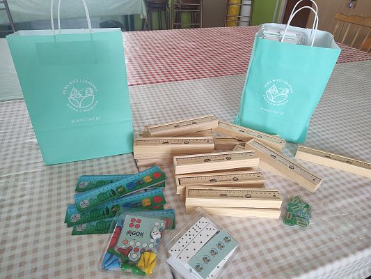 Na zdjęciu gadżety przekazane przez urząd gminy: linijki, drewniane piórniki, małe składane puzzle oraz gra domino