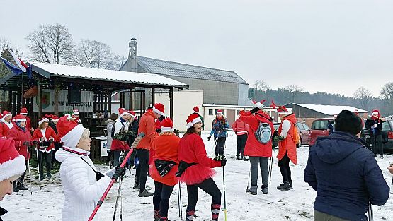 Grupa ludzi na tle zimowej scenerii podczas rozgrzewki przed marszem. grafika