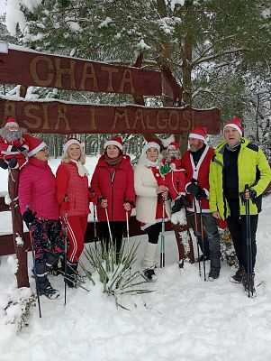 Pięć osób w strojach Mikołaja, w tle zimowa sceneria.
