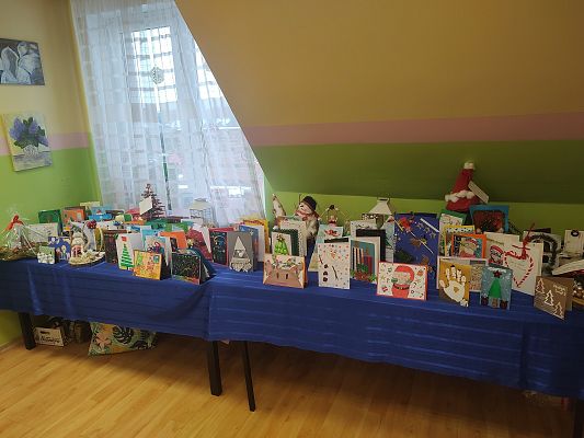 Zdjęcie przedstawia stoły nakryte niebieskim obrusem, a na nich kartki przygotowane przez dzieci.