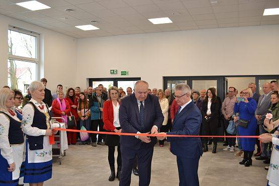 Pani Mariola Wiśniewska sołtys Mostów przecina czerwoną wstęgę, w tle pozostali goście na otwarciu.