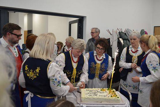 Panie z KGW częstują przybyłych gości okolicznościowym tortem.